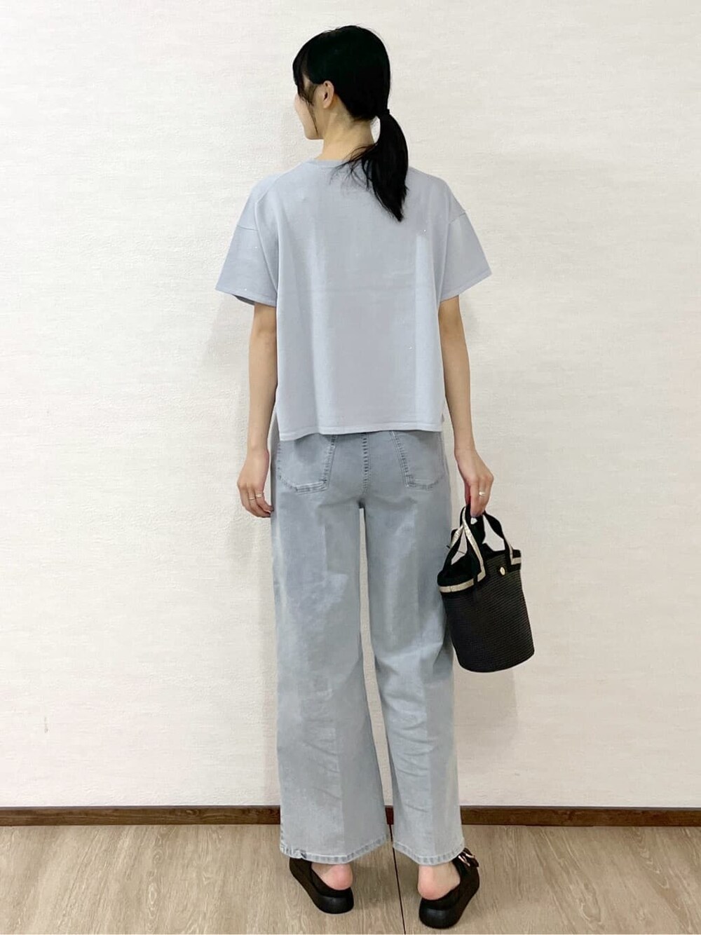 グレー系のニット/セーター、ブルー系のデニムパンツ、ブラック系のトートバッグを着用したレディースの夏コーディネートの4枚目の写真