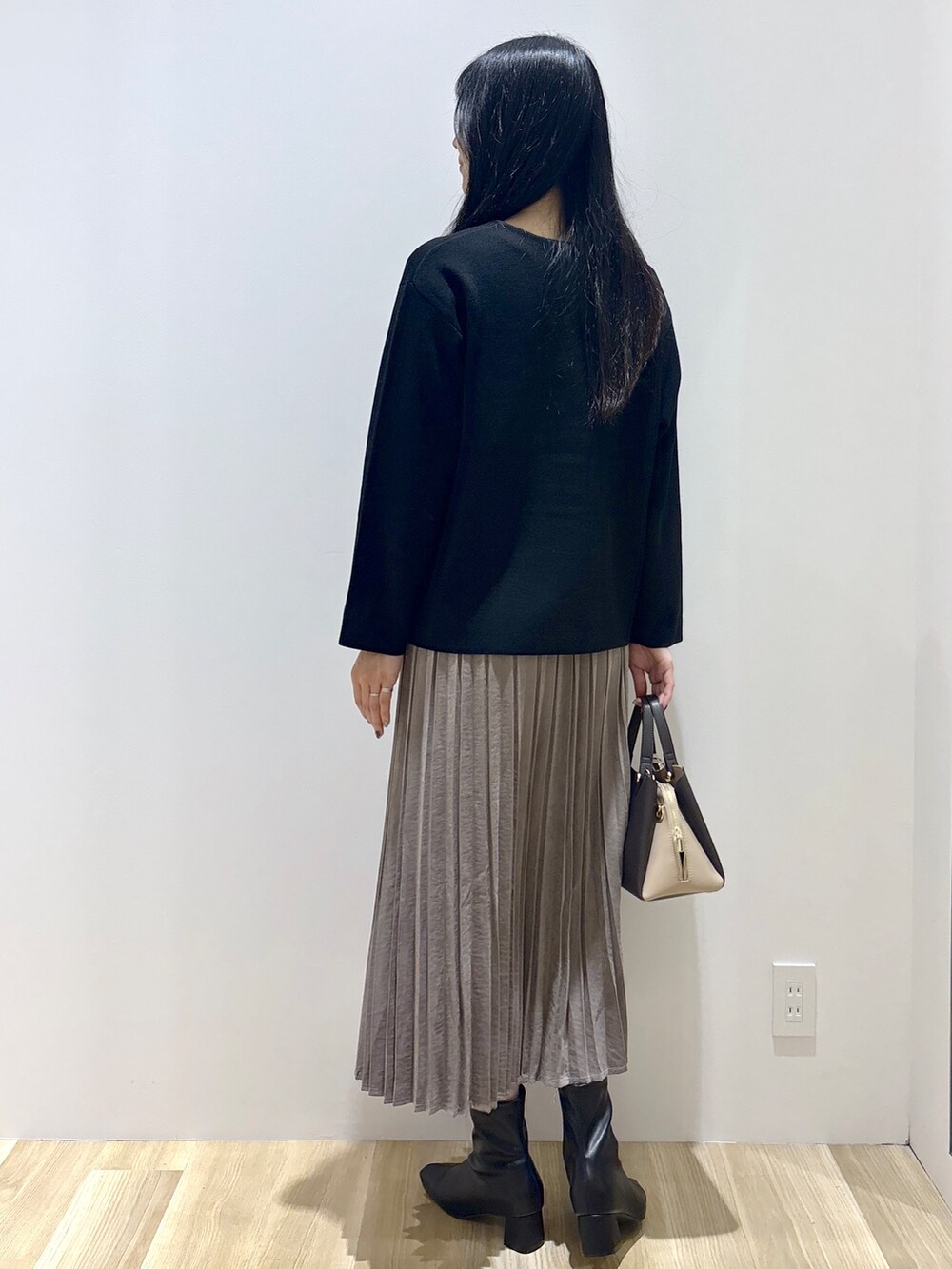 ブラック系のカーディガン/ボレロ、ブラウン系のスカート、ブラウン系のボストンバッグを着用したレディースの秋コーディネートの4枚目の写真