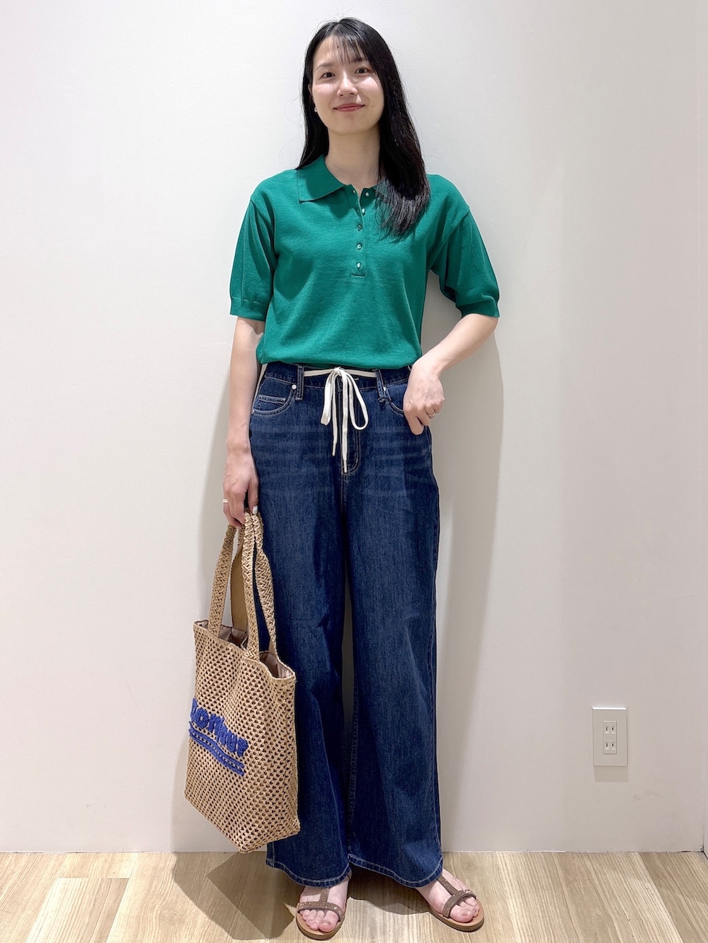 その他のサンダル、ベージュ系のトートバッグ、ブルー系のデニムパンツを着用したレディースの春コーディネートの2枚目の写真