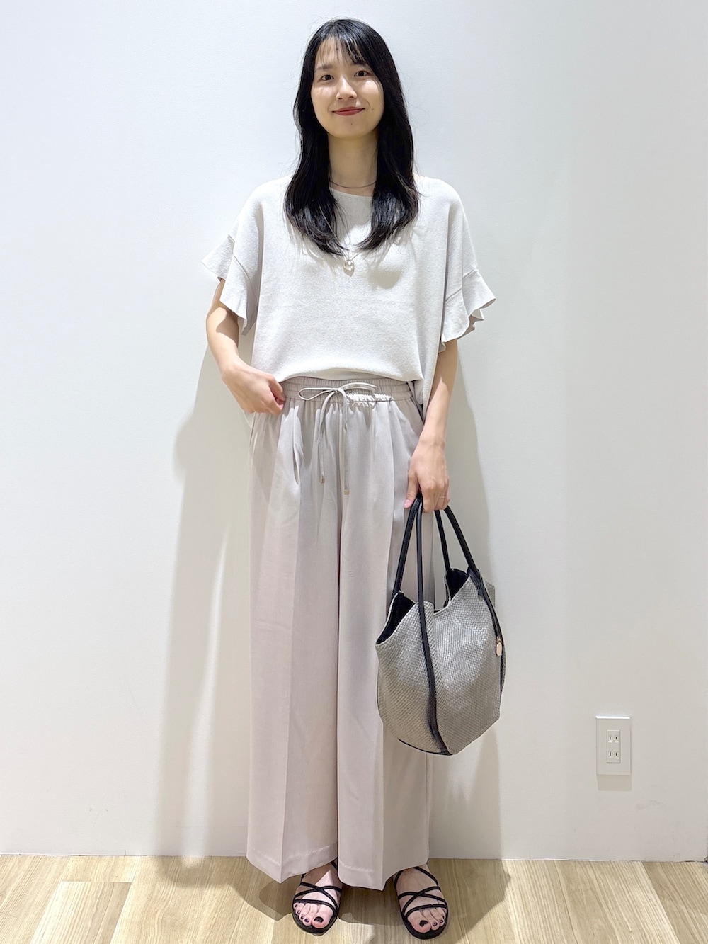 ベージュ系のその他パンツ、ブラック系のサンダル、グレー系のトートバッグを着用したレディースの春コーディネートの8枚目の写真
