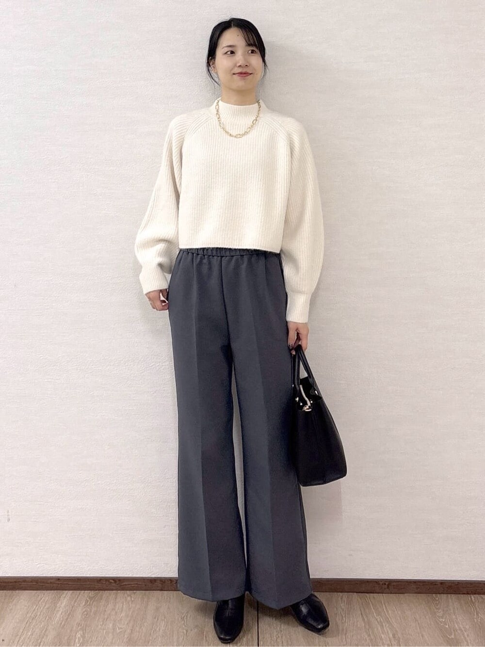 ホワイト系のニット/セーター、グレー系のその他パンツ、ブラック系のトートバッグを着用したレディースの冬コーディネートの7枚目の写真
