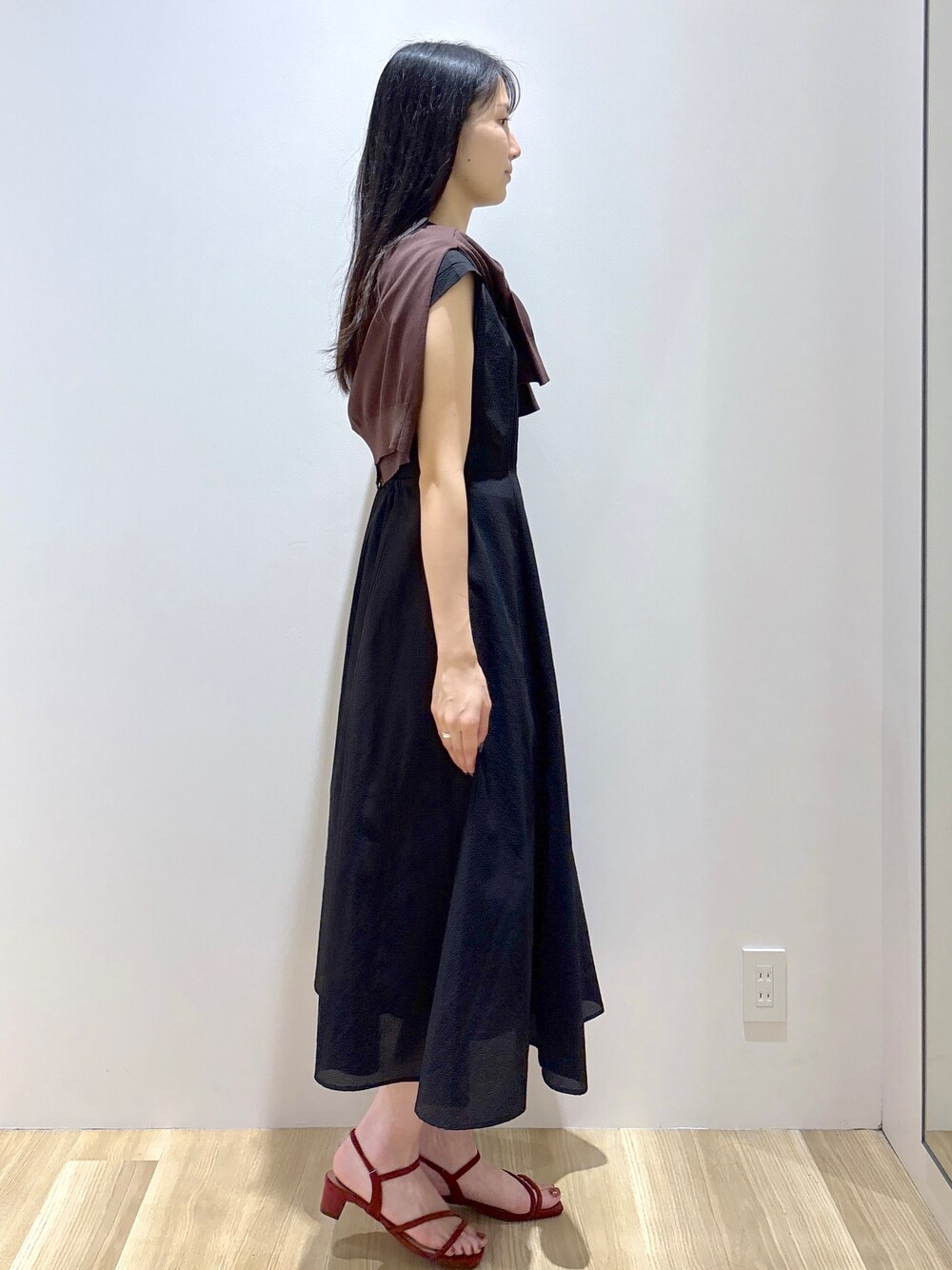 ブラウン系のカーディガン/ボレロ、ブラック系のワンピース、ブラウン系のトートバッグを着用したレディースの夏コーディネートの5枚目の写真
