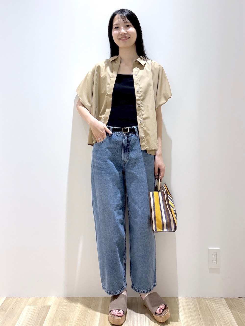 ベージュ系のシャツ/ブラウス、ブラック系のタンクトップ、ブルー系のデニムパンツを着用したレディースの夏コーディネートの2枚目の写真