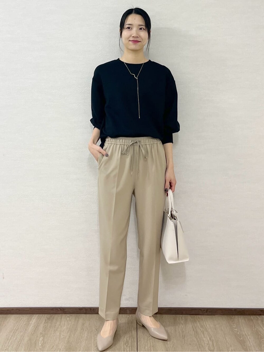 ブラック系のノーカラーコート、ブラック系のTシャツ/カットソー、ベージュ系のその他パンツを着用したレディースの冬コーディネートの10枚目の写真