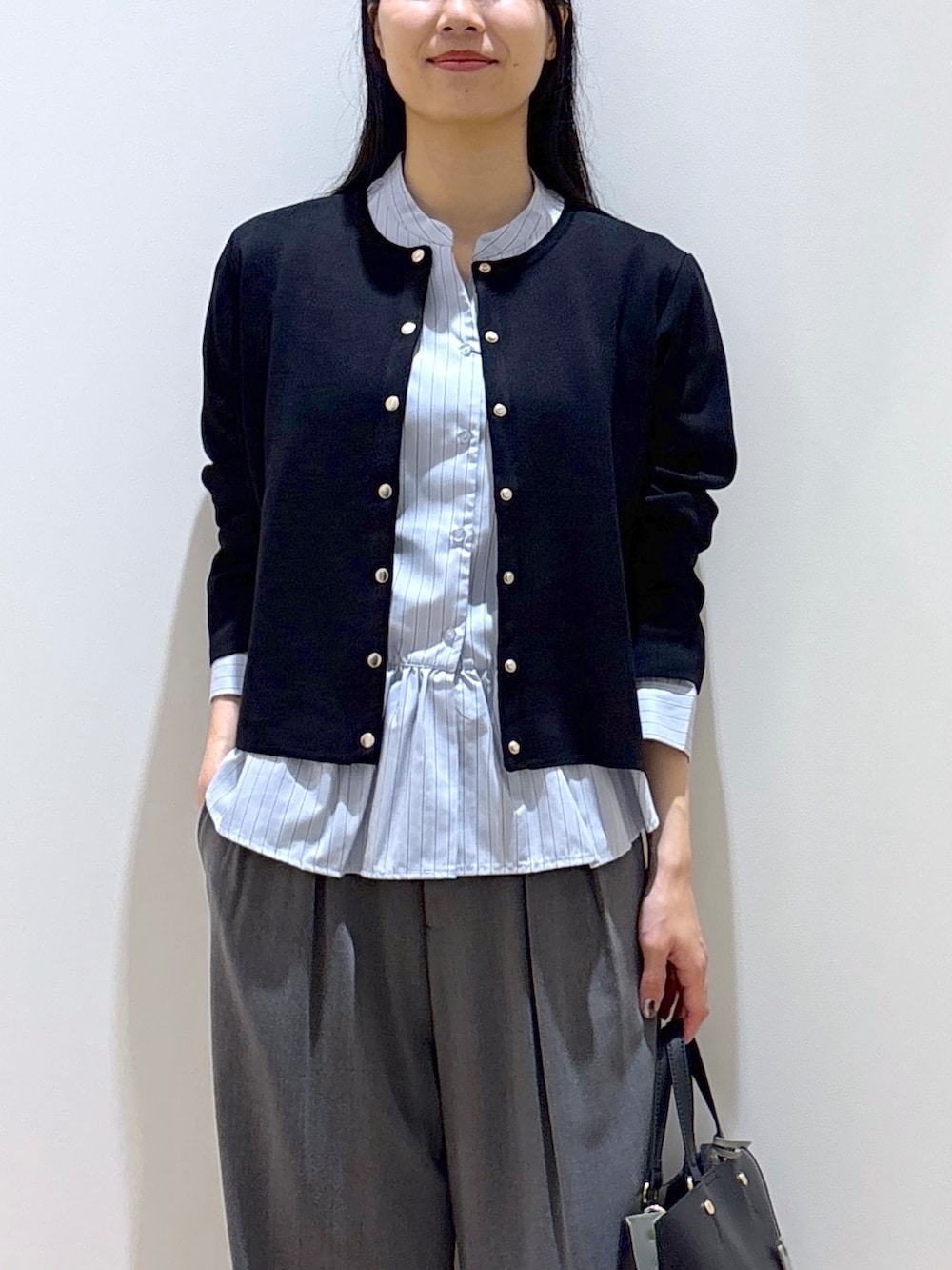 ブラック系のカーディガン/ボレロ、ブルー系のシャツ/ブラウス、グレー系のその他パンツを着用したレディースの秋コーディネートの6枚目の写真