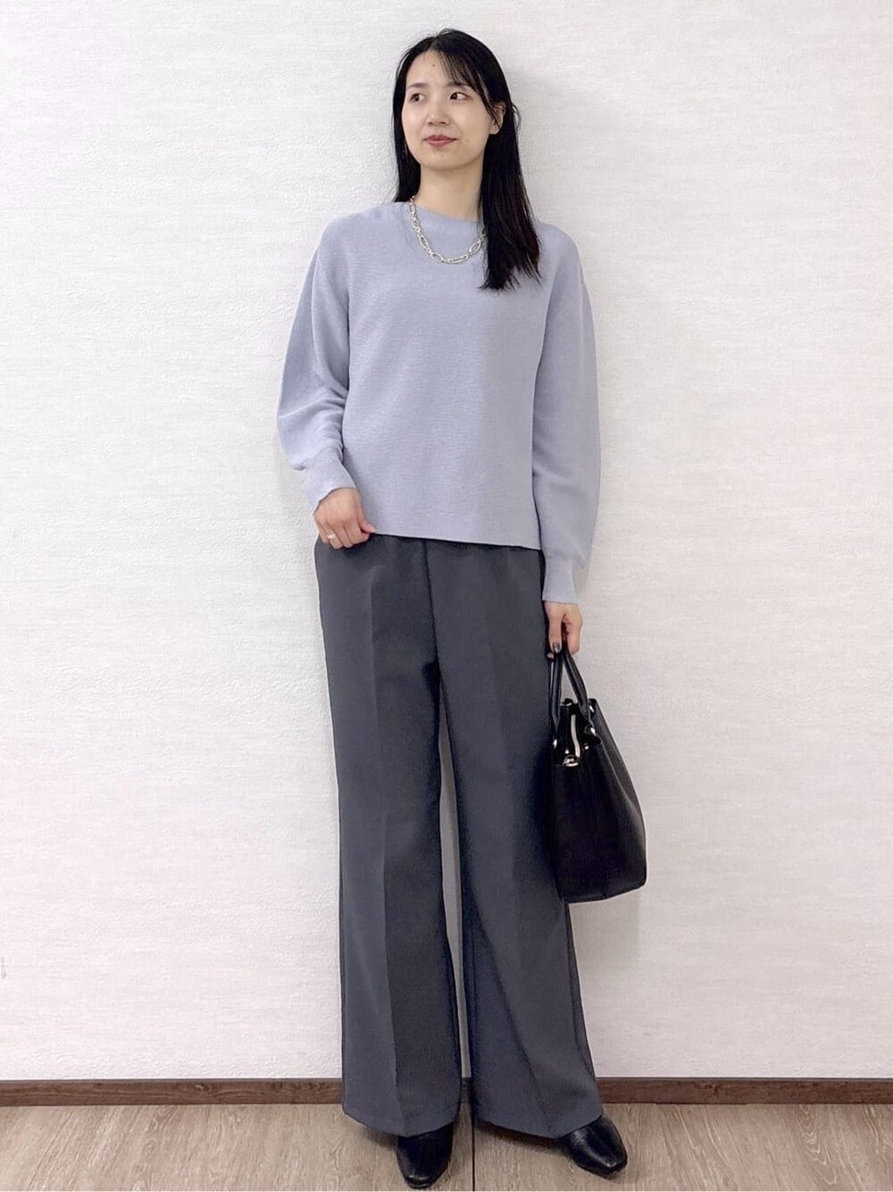 ブルー系のニット/セーター、グレー系のその他パンツ、ブラック系のトートバッグを着用したレディースの冬コーディネートの10枚目の写真