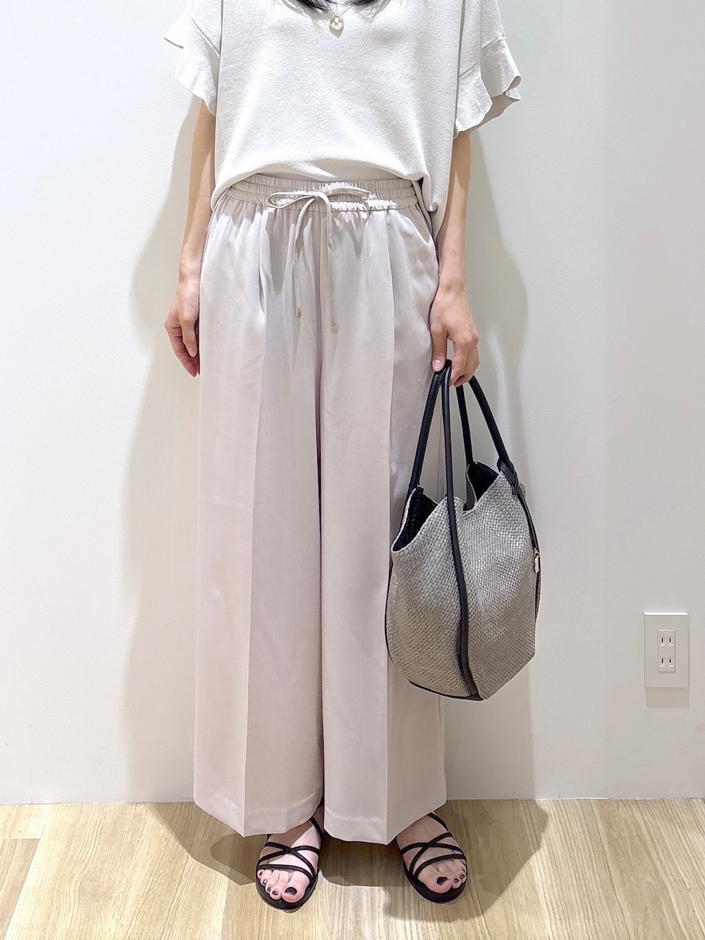 ベージュ系のその他パンツ、ブラック系のサンダル、グレー系のトートバッグを着用したレディースの春コーディネートの7枚目の写真