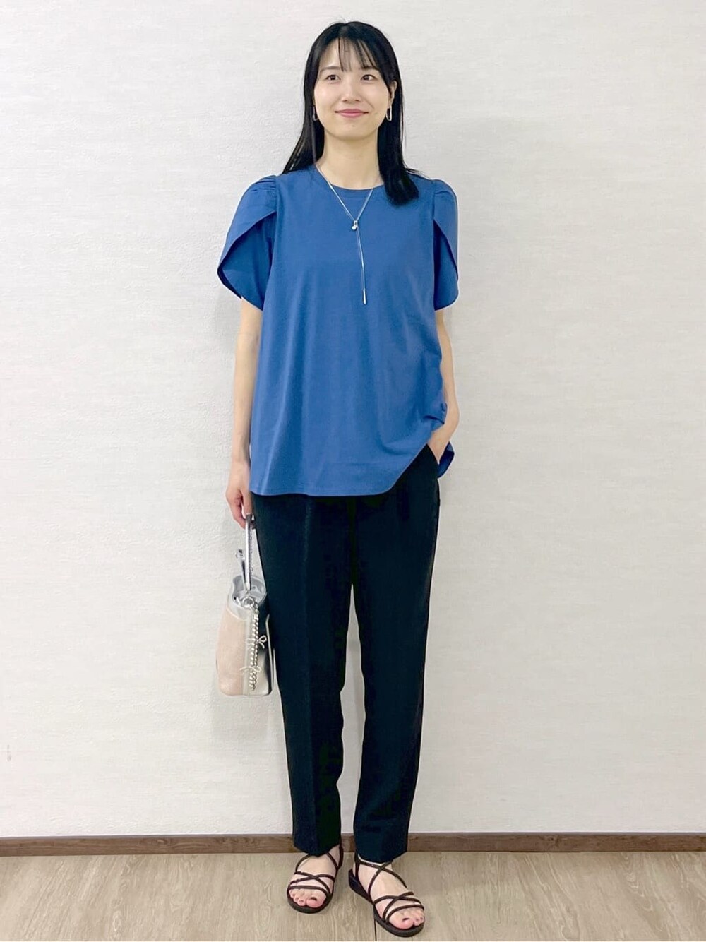 ブルー系のTシャツ/カットソー、ブラック系のその他パンツ、シルバー系のショルダーバッグを着用したレディースの春コーディネートの2枚目の写真
