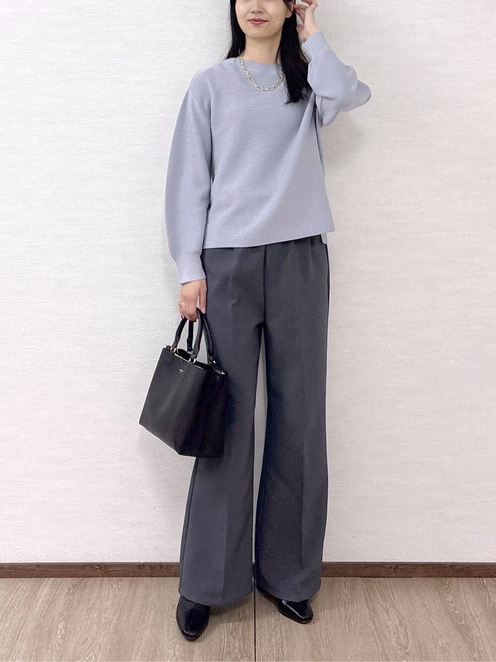 ブルー系のニット/セーター、グレー系のその他パンツ、ブラック系のトートバッグを着用したレディースの冬コーディネートの7枚目の写真