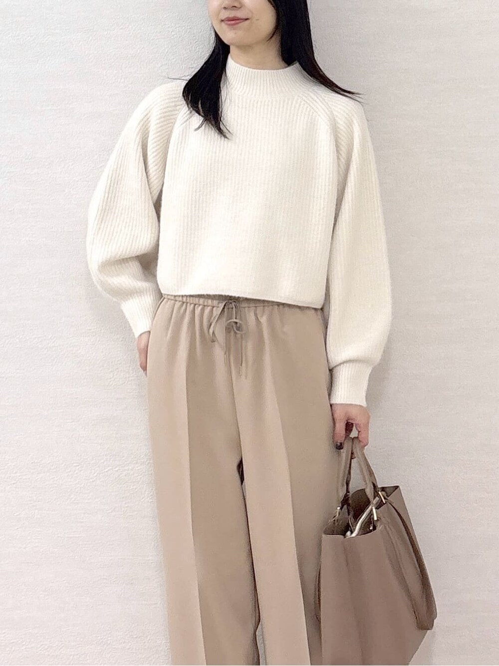 ホワイト系のニット/セーター、ベージュ系のその他パンツ、ベージュ系のトートバッグを着用したレディースの冬コーディネートの6枚目の写真