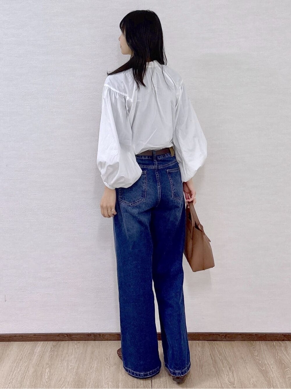 ホワイト系のシャツ/ブラウス、ブルー系のデニムパンツ、ブラウン系のトートバッグを着用したレディースの春コーディネートの4枚目の写真
