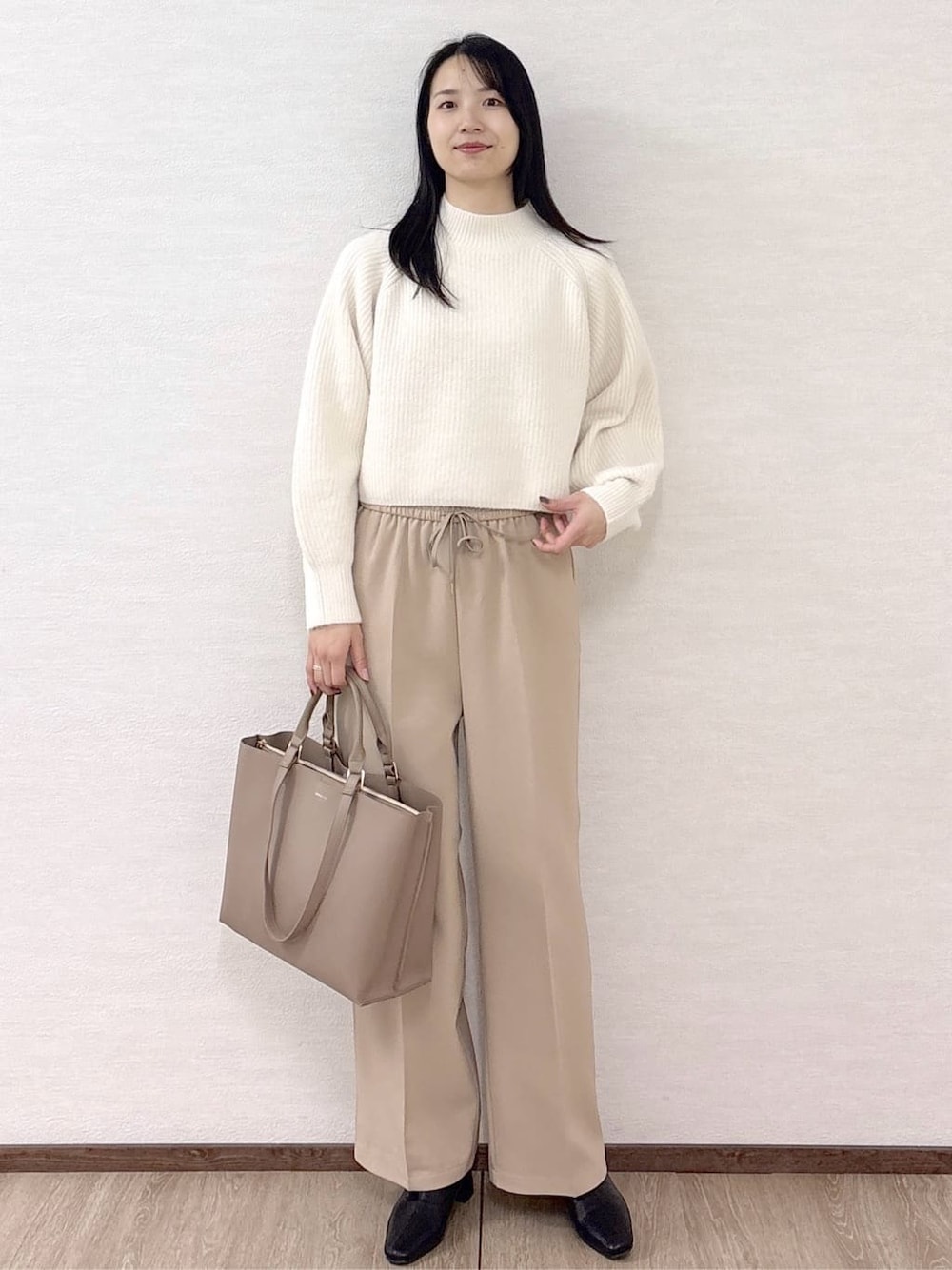 ホワイト系のニット/セーター、ベージュ系のその他パンツ、ベージュ系のトートバッグを着用したレディースの冬コーディネートの2枚目の写真