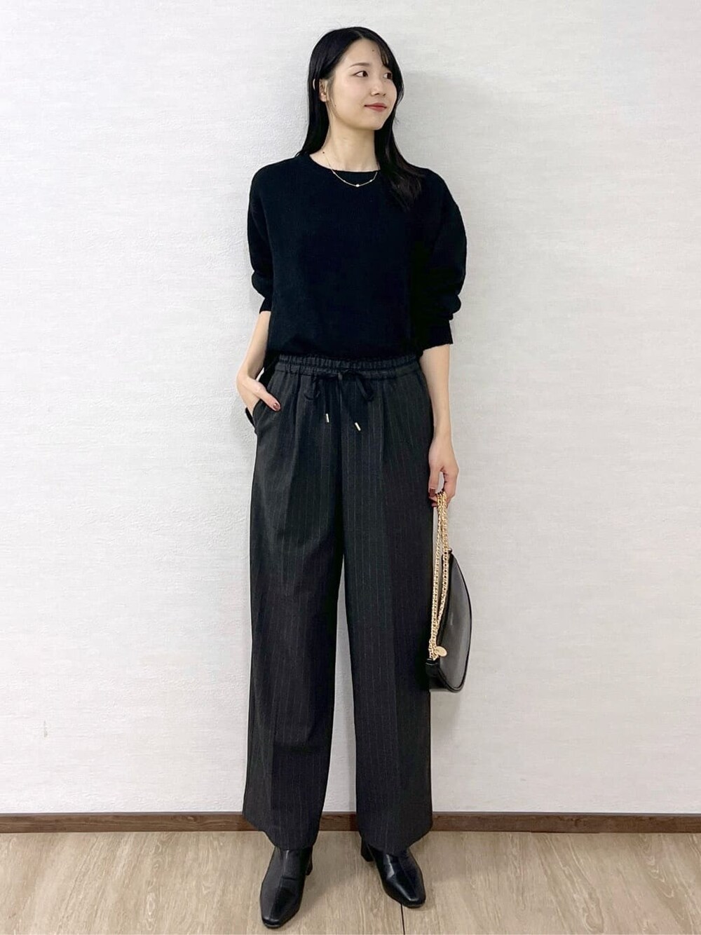 ブラック系のニット/セーター、グレー系のその他パンツ、ブラック系のハンドバッグを着用したレディースの冬コーディネートの8枚目の写真