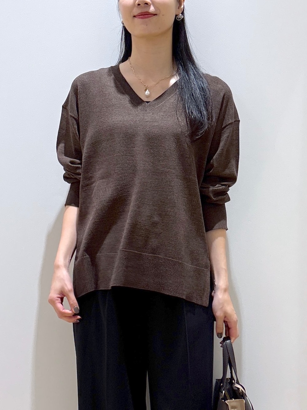 ブラウン系のニット/セーター、ブラック系のその他パンツ、ブラウン系のトートバッグを着用したレディースの秋コーディネートの6枚目の写真