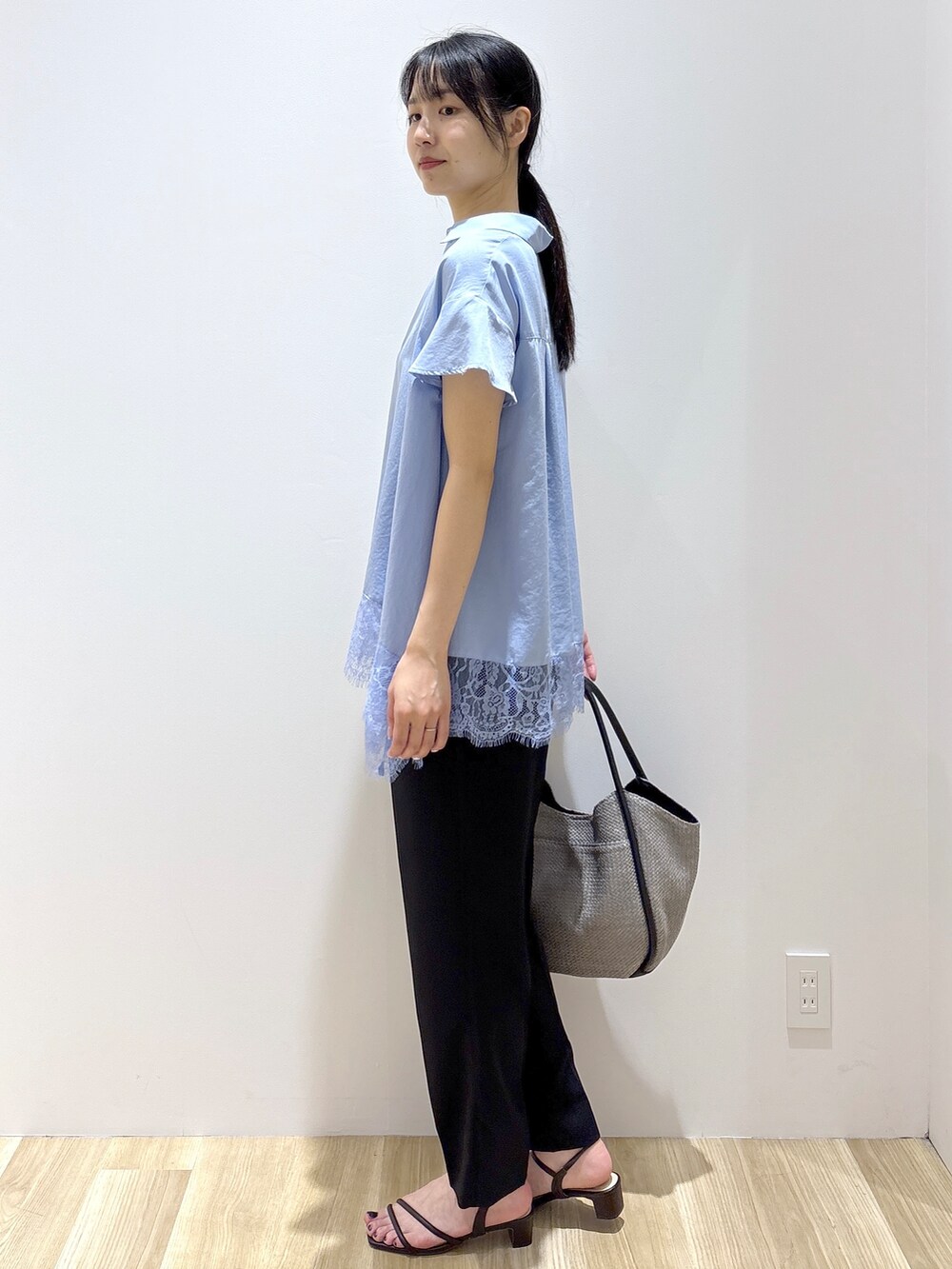 ブルー系のシャツ/ブラウス、ブラック系のその他パンツ、グレー系のトートバッグを着用したレディースの春コーディネートの3枚目の写真