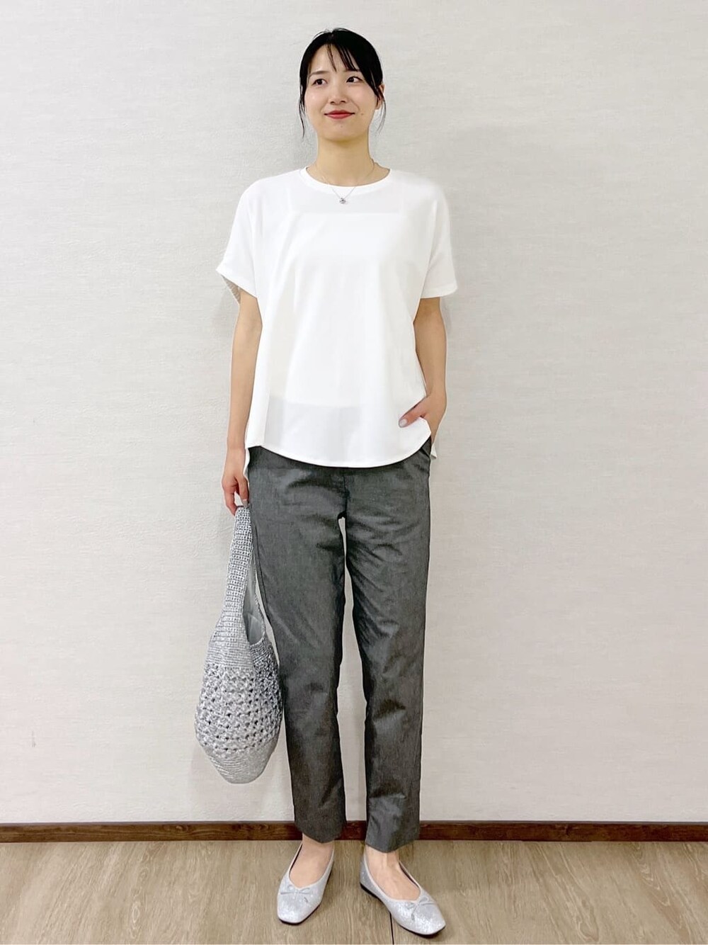 ホワイト系のTシャツ/カットソー、グレー系のその他パンツ、ブラック系のボストンバッグを着用したレディースの夏コーディネートの2枚目の写真