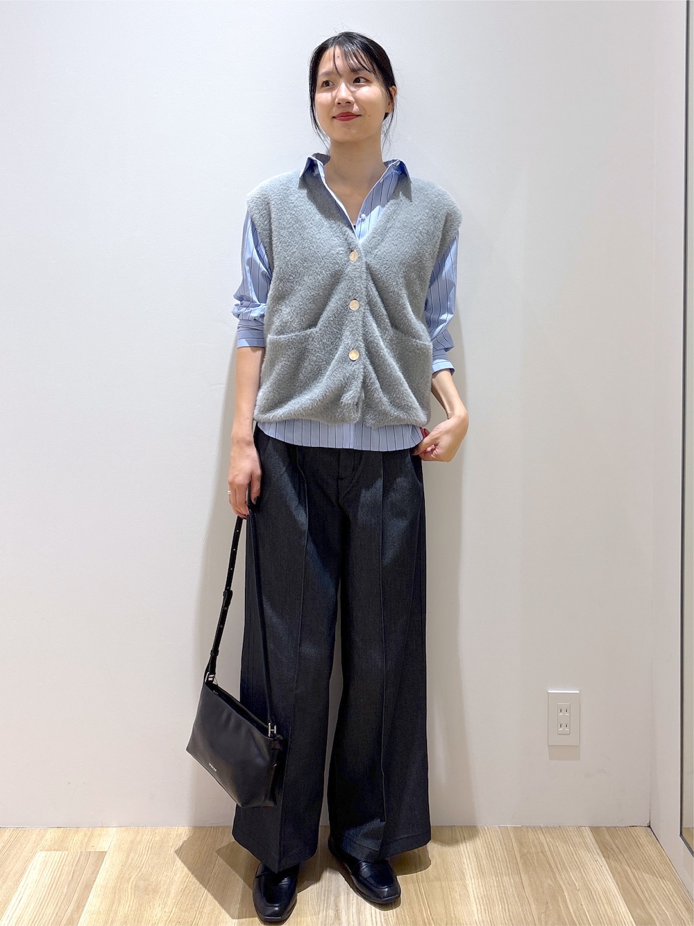 グレー系のニット/セーター、ブラック系のその他パンツ、ブラック系のショルダーバッグを着用したレディースの秋コーディネートの2枚目の写真