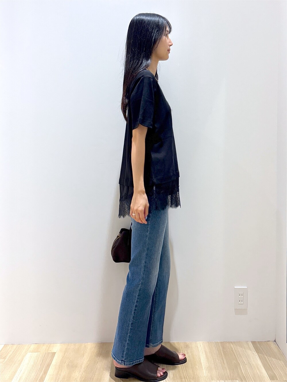 ブラック系のTシャツ/カットソー、ブルー系のデニムパンツ、ブラウン系のボストンバッグを着用したレディースの夏コーディネートの5枚目の写真