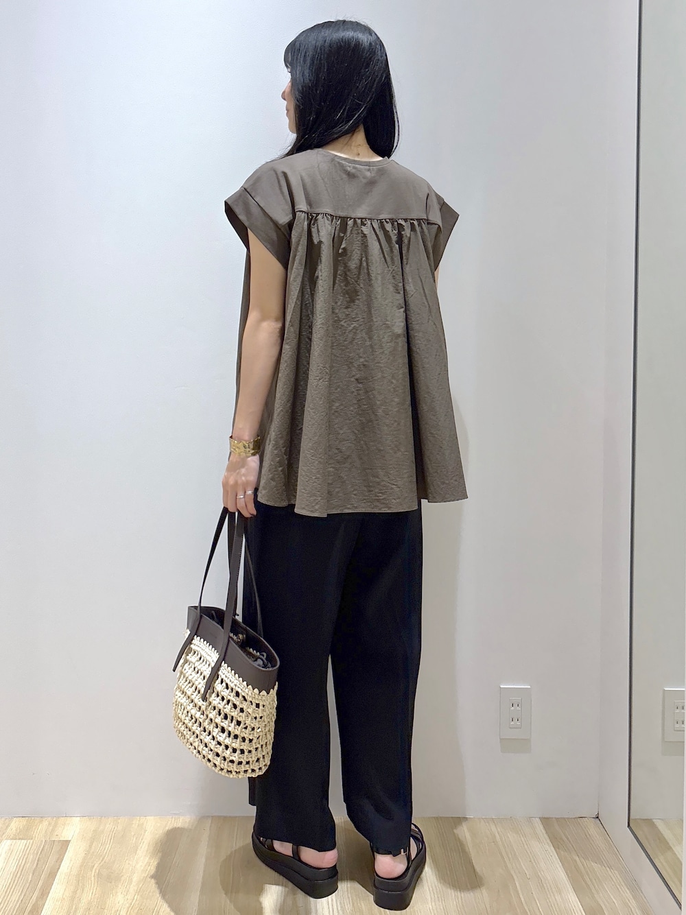 ブラウン系のTシャツ/カットソー、ブラック系のその他パンツ、ブラウン系のトートバッグを着用したレディースの夏コーディネートの4枚目の写真