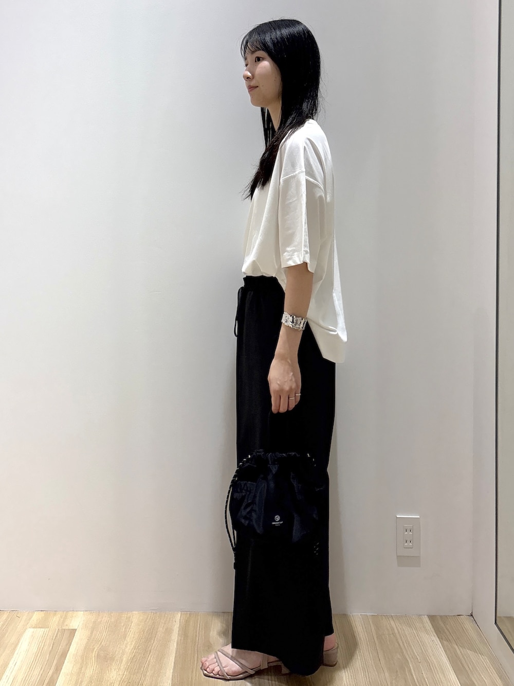ホワイト系のTシャツ/カットソー、グレー系のその他パンツ、ブラック系のショルダーバッグを着用したレディースの夏コーディネートの2枚目の写真