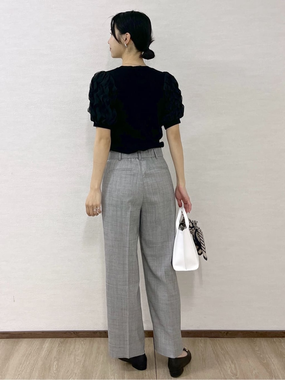 ブラック系のTシャツ/カットソー、グレー系のその他パンツ、ホワイト系のトートバッグを着用したレディースの春コーディネートの5枚目の写真