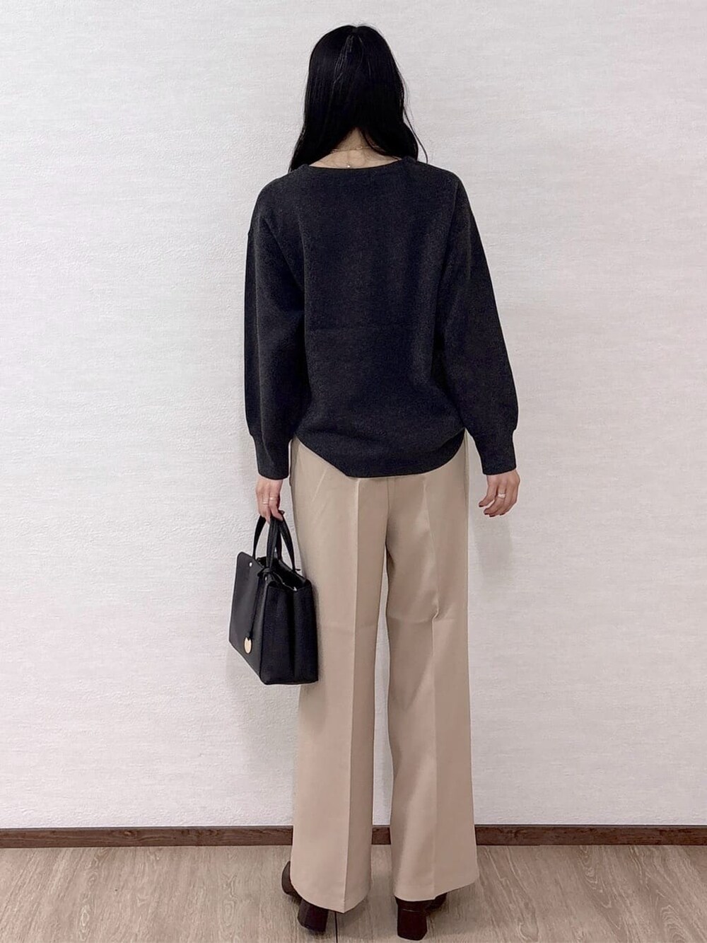 グレー系のニット/セーター、ベージュ系のその他パンツ、ブラック系のトートバッグを着用したレディースの冬コーディネートの4枚目の写真