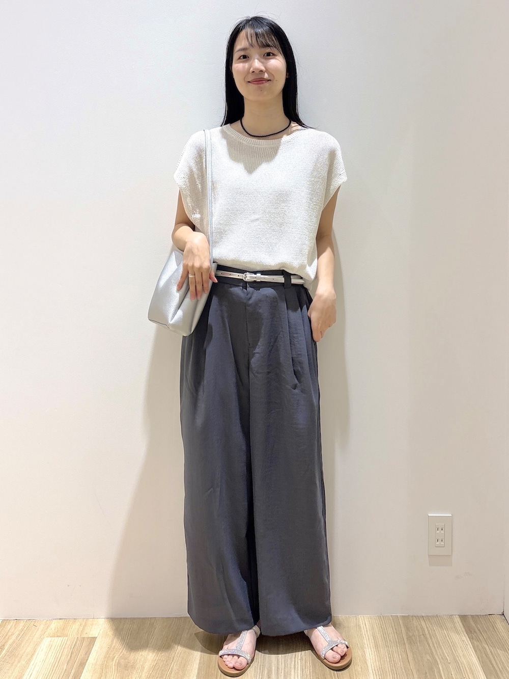ホワイト系のニット/セーター、グレー系のその他パンツ、シルバー系のショルダーバッグを着用したレディースの夏コーディネートの8枚目の写真