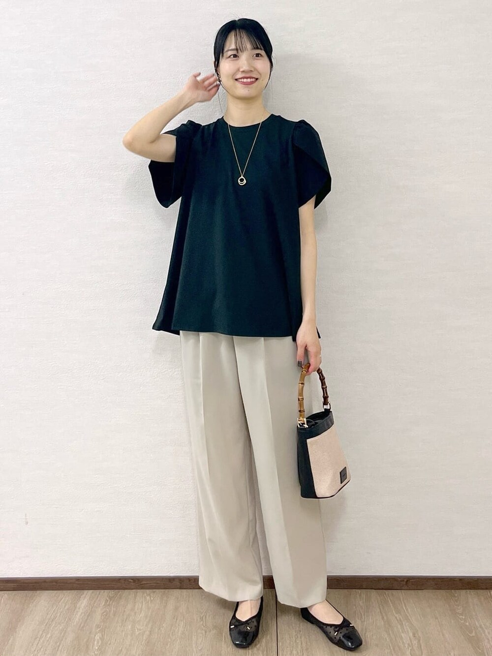 ブラック系のTシャツ/カットソー、ベージュ系のその他パンツ、ブラック系のショルダーバッグを着用したレディースの春コーディネートの10枚目の写真