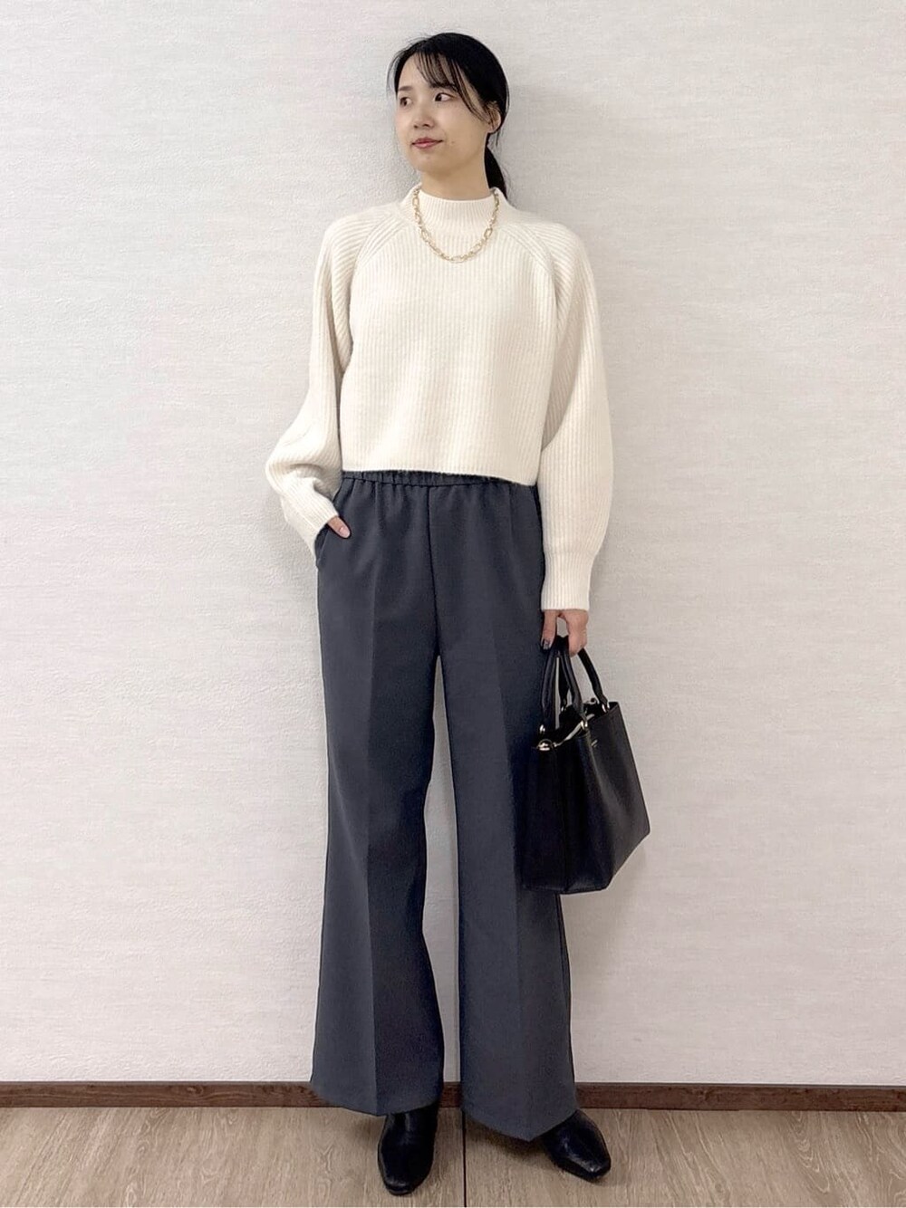 ホワイト系のニット/セーター、グレー系のその他パンツ、ブラック系のトートバッグを着用したレディースの冬コーディネートの8枚目の写真