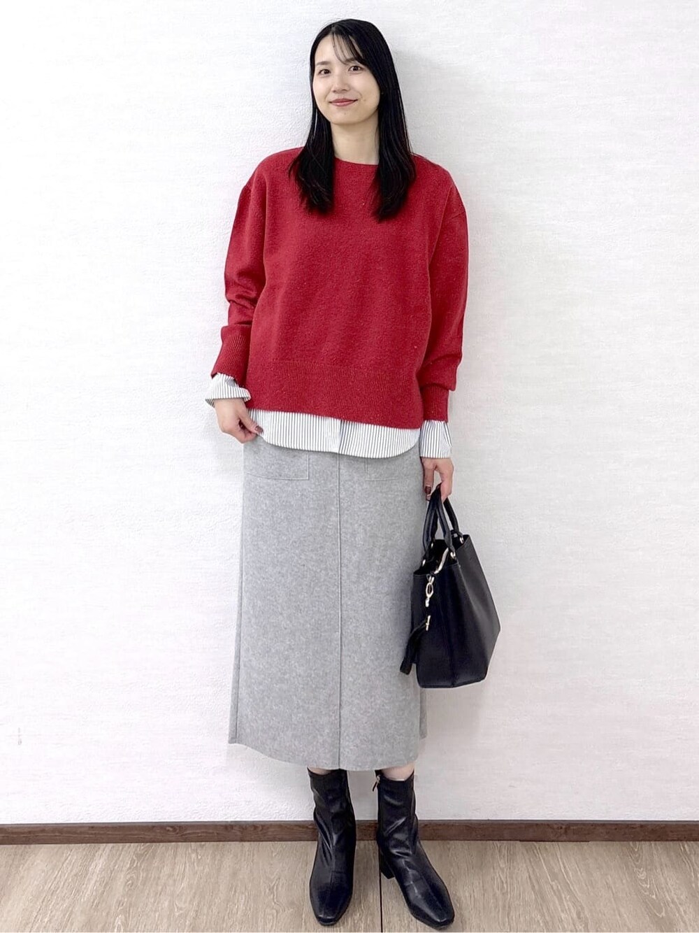 ブラック系のノーカラーコート、レッド系のニット/セーター、ホワイト系のTシャツ/カットソーを着用したレディースの冬コーディネートの9枚目の写真