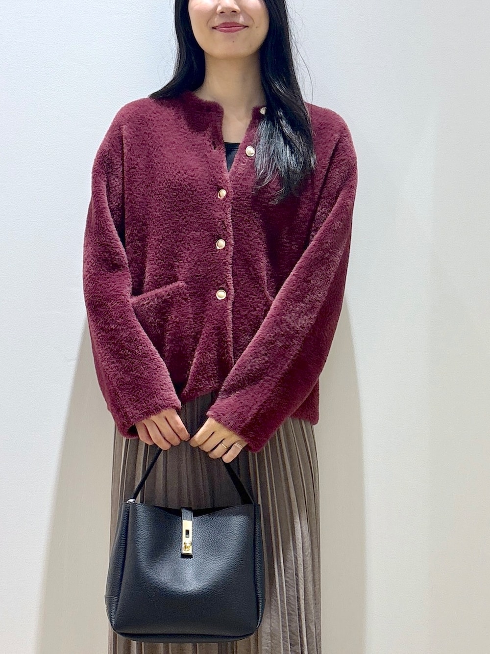 レッド系のカーディガン/ボレロ、ブラウン系のスカート、ブラック系のトートバッグを着用したレディースの秋コーディネートの6枚目の写真