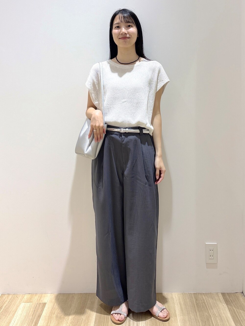 ホワイト系のニット/セーター、グレー系のその他パンツ、シルバー系のショルダーバッグを着用したレディースの夏コーディネートの7枚目の写真