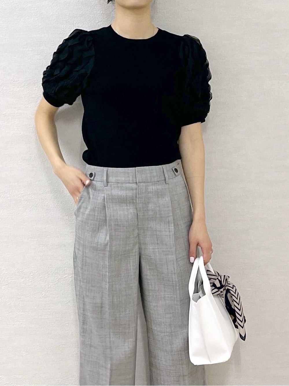 ブラック系のTシャツ/カットソー、グレー系のその他パンツ、ホワイト系のトートバッグを着用したレディースの春コーディネートの7枚目の写真