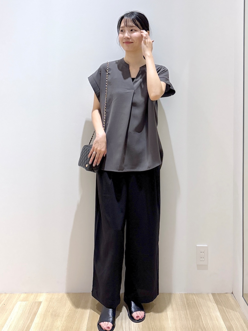 ブラック系のその他パンツ、ブラック系のショルダーバッグ、ブラック系のサンダルを着用したレディースの夏コーディネートの2枚目の写真