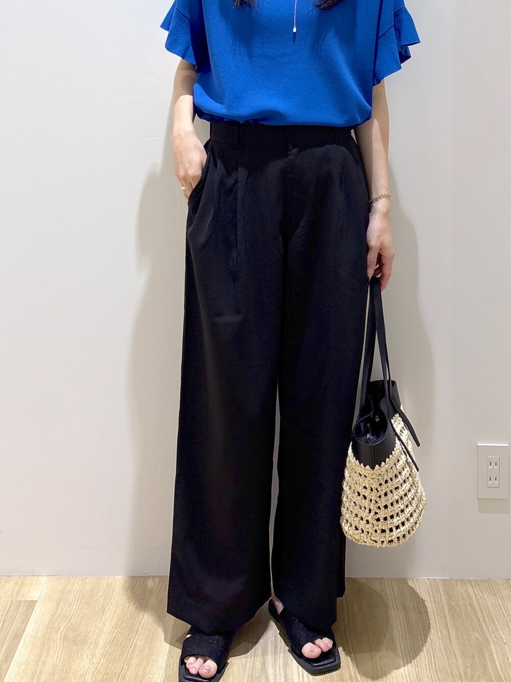 ブルー系のニット/セーター、ブラック系のその他パンツ、ブラック系のトートバッグを着用したレディースの夏コーディネートの7枚目の写真