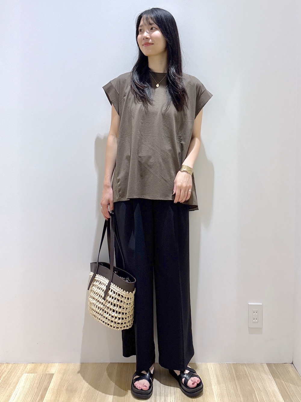 ブラウン系のTシャツ/カットソー、ブラック系のその他パンツ、ブラウン系のトートバッグを着用したレディースの夏コーディネートの2枚目の写真