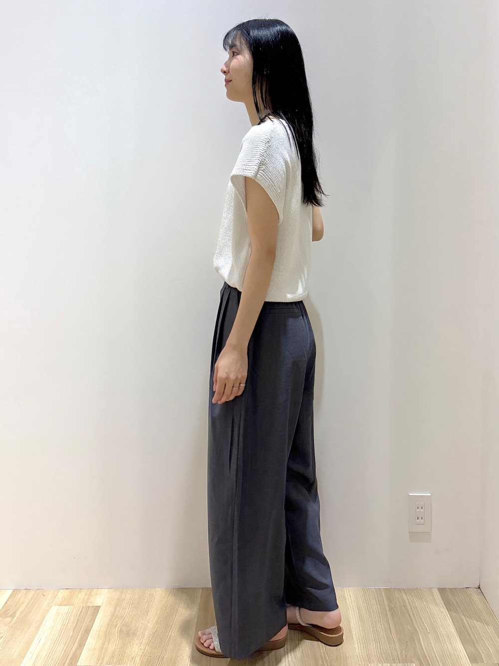 ホワイト系のニット/セーター、グレー系のその他パンツ、シルバー系のショルダーバッグを着用したレディースの夏コーディネートの3枚目の写真