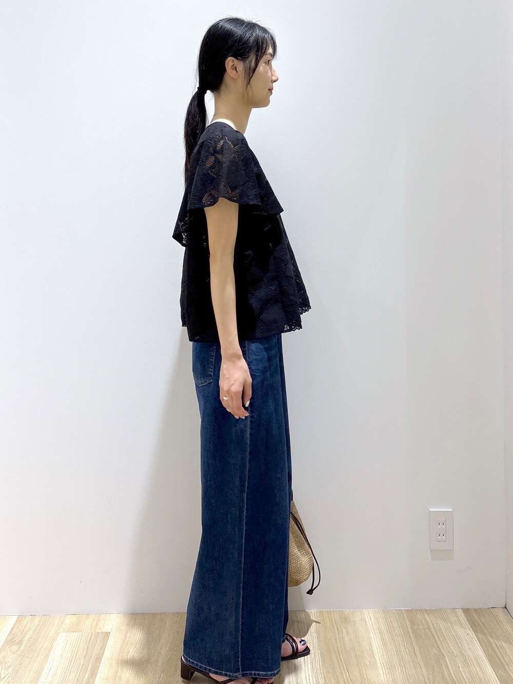 ブラック系のシャツ/ブラウス、ブルー系のデニムパンツ、ベージュ系のトートバッグを着用したレディースの春コーディネートの5枚目の写真