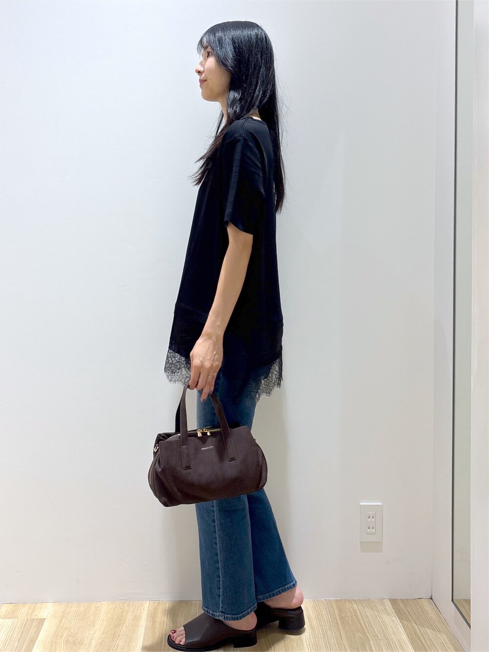 ブラック系のTシャツ/カットソー、ブルー系のデニムパンツ、ブラウン系のボストンバッグを着用したレディースの夏コーディネートの3枚目の写真