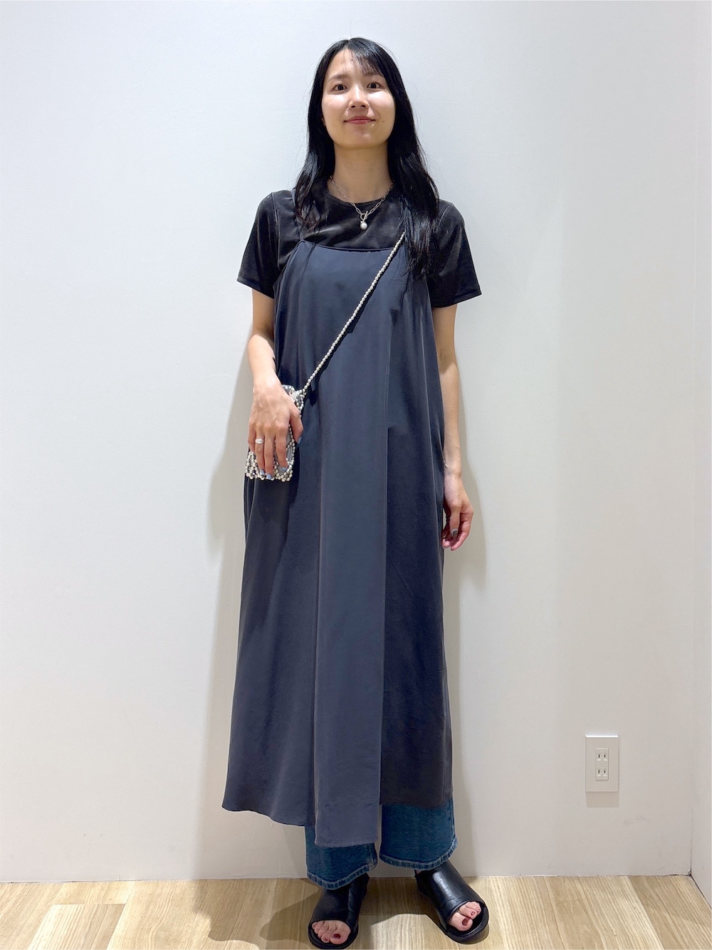 グレー系のワンピース、グレー系のTシャツ/カットソー、ブルー系のデニムパンツを着用したレディースの夏コーディネートの6枚目の写真