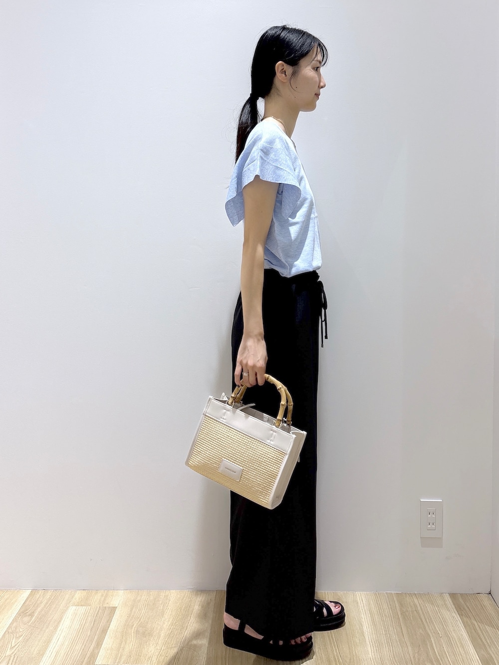 ブルー系のニット/セーター、グレー系のその他パンツ、ホワイト系のトートバッグを着用したレディースの夏コーディネートの5枚目の写真