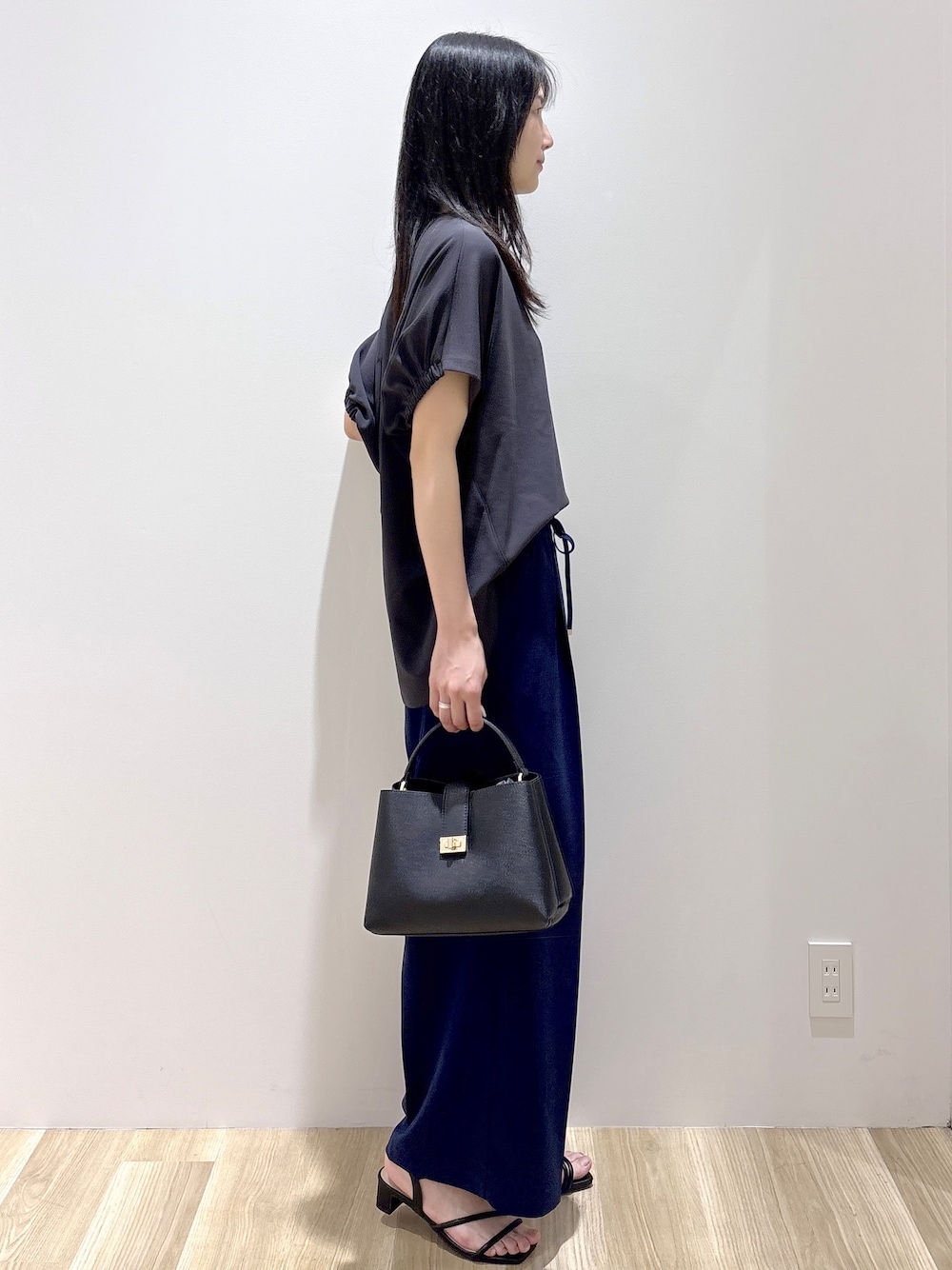 ブラック系のハンドバッグ、ベージュ系のショルダーバッグ、グレー系のTシャツ/カットソーを着用したレディースの春コーディネートの5枚目の写真