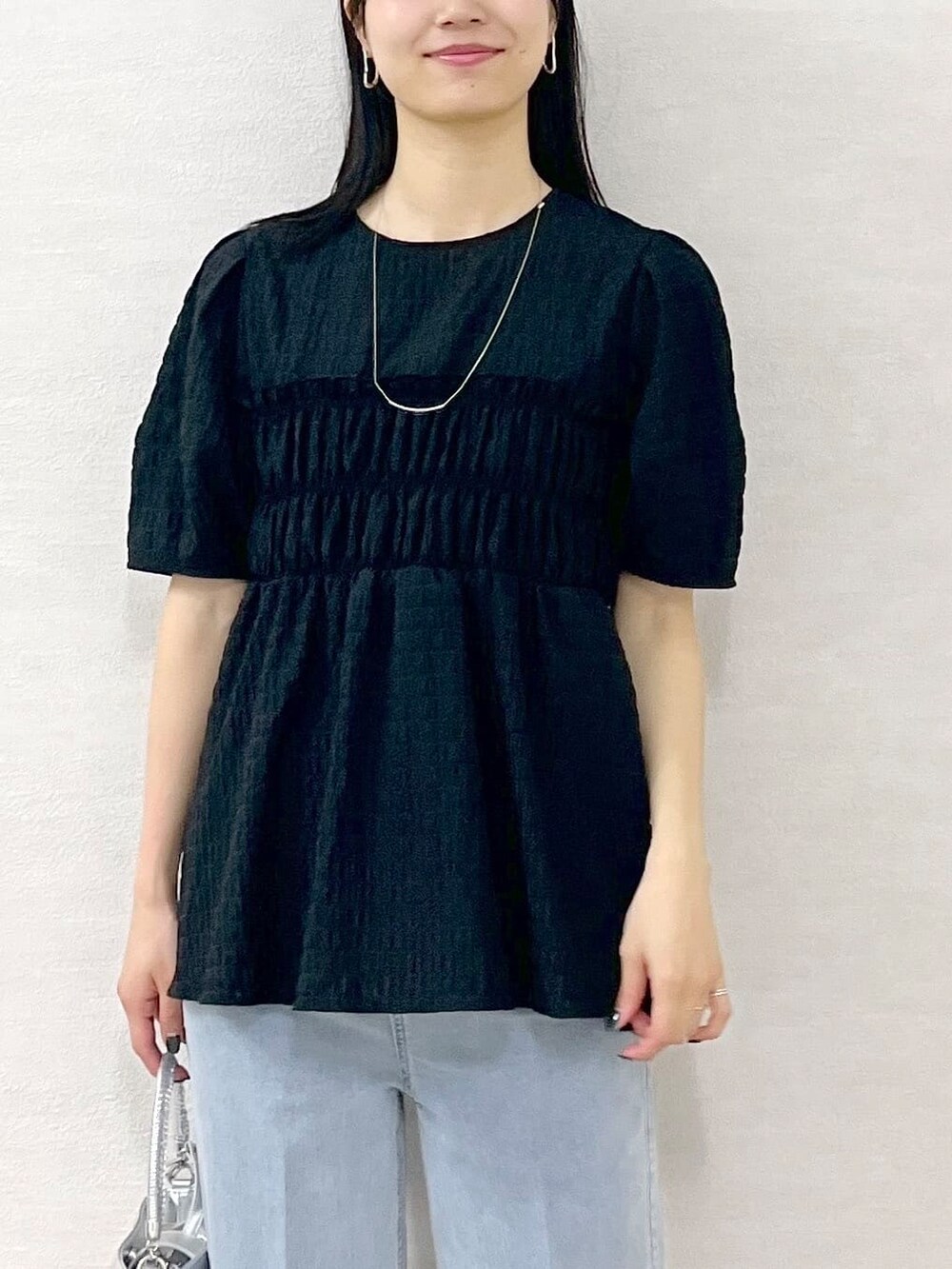 ブラック系のシャツ/ブラウス、ブルー系のデニムパンツ、シルバー系のショルダーバッグを着用したレディースの春コーディネートの9枚目の写真