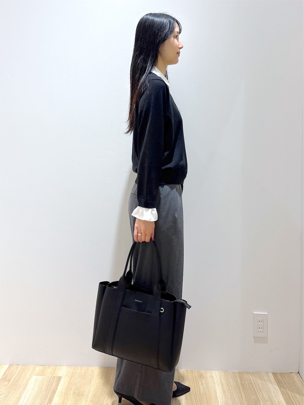 ブラック系のニット/セーター、グレー系のその他パンツ、ブラック系のトートバッグを着用したレディースの秋コーディネートの5枚目の写真