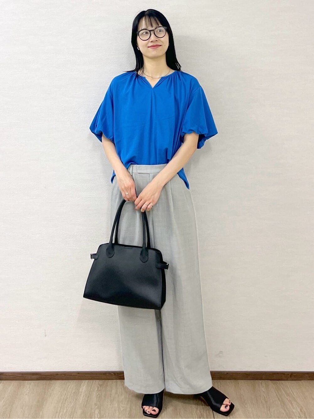 ブルー系のTシャツ/カットソー、グレー系のその他パンツ、ブラック系のボストンバッグを着用したレディースの夏コーディネートの2枚目の写真