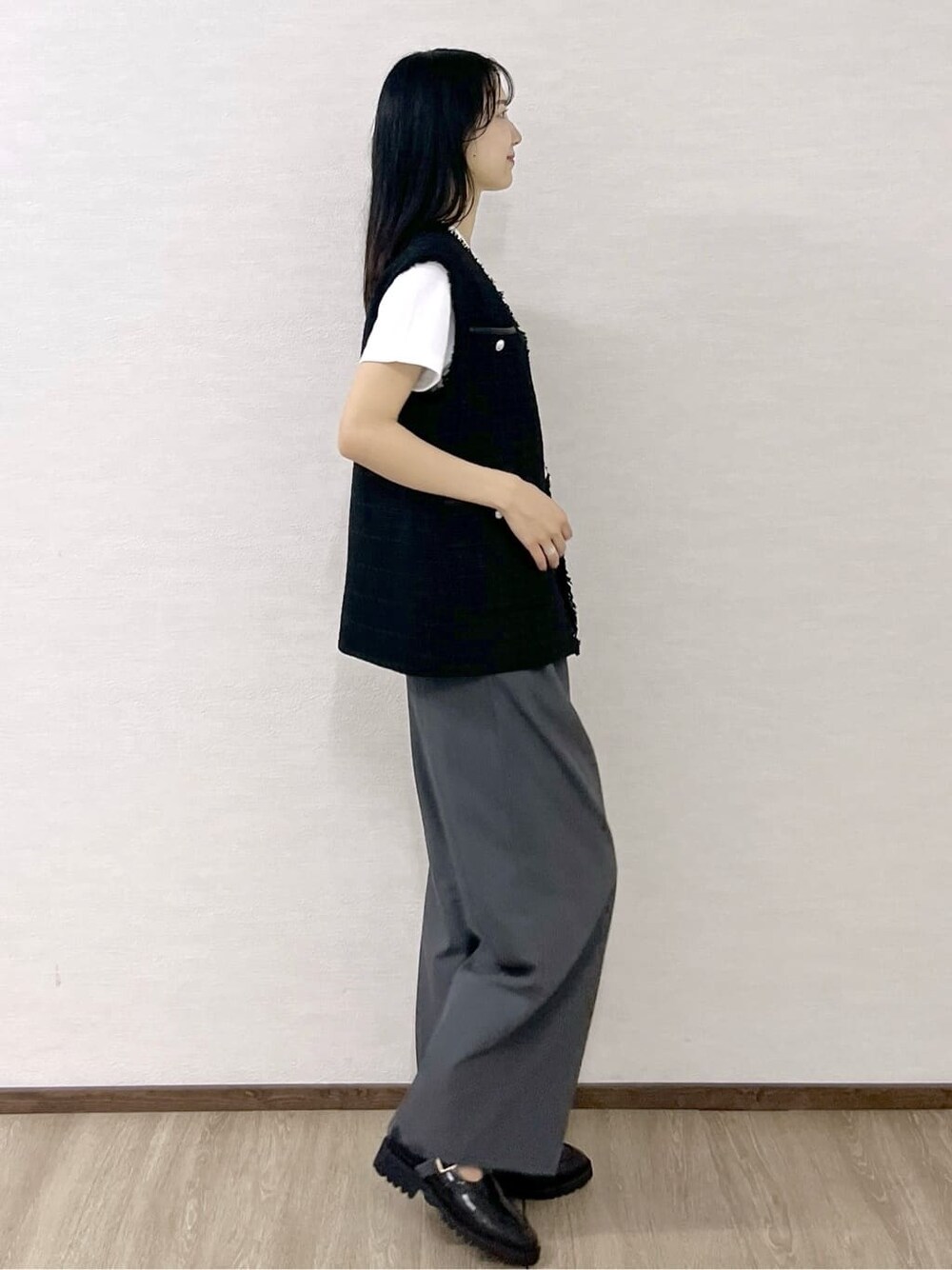 ブラック系のベスト、ホワイト系のTシャツ/カットソー、グレー系のその他パンツを着用したレディースの秋コーディネートの5枚目の写真