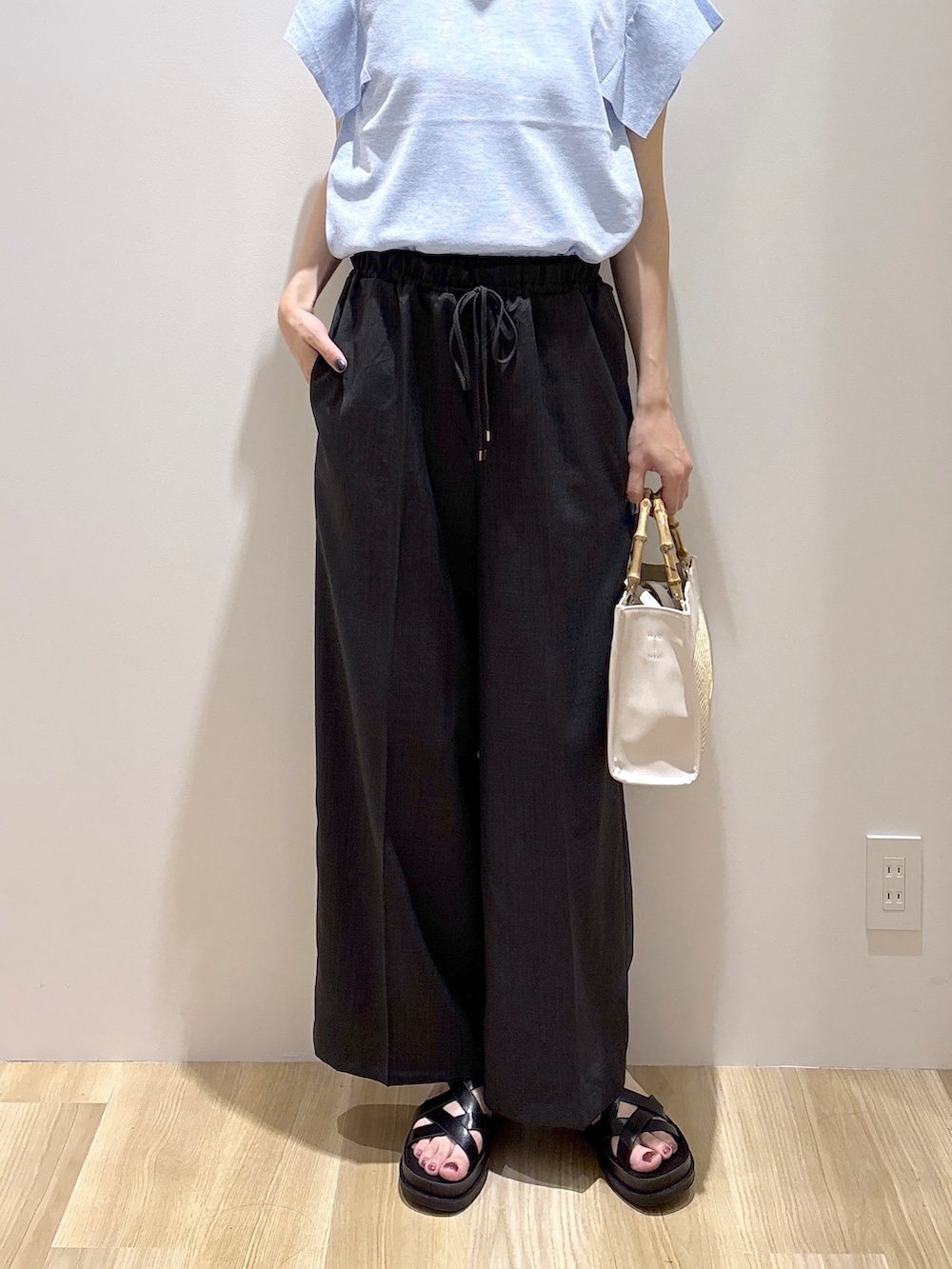 ブルー系のニット/セーター、グレー系のその他パンツ、ホワイト系のトートバッグを着用したレディースの夏コーディネートの7枚目の写真