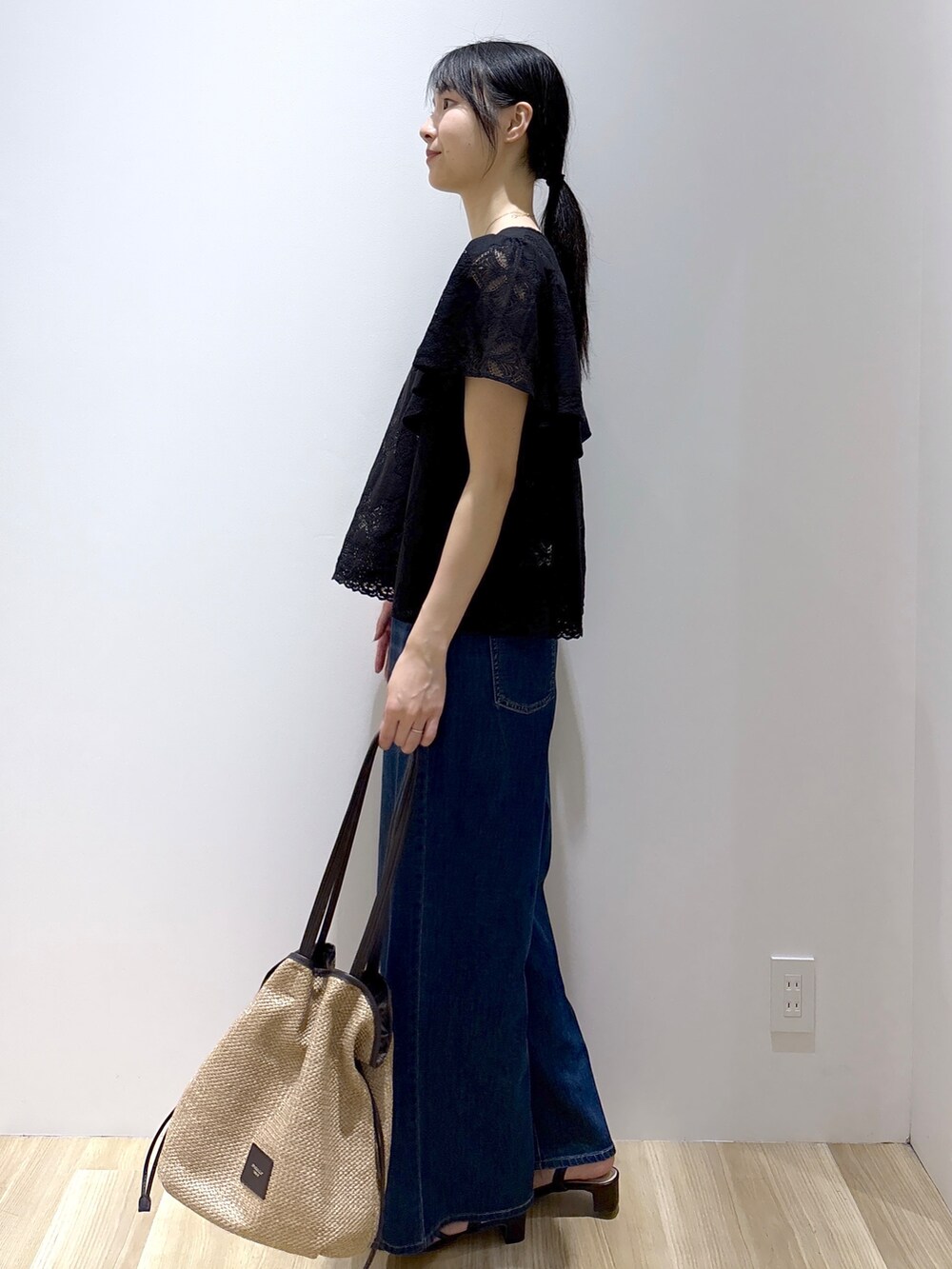 ブラック系のシャツ/ブラウス、ブルー系のデニムパンツ、ベージュ系のトートバッグを着用したレディースの春コーディネートの3枚目の写真
