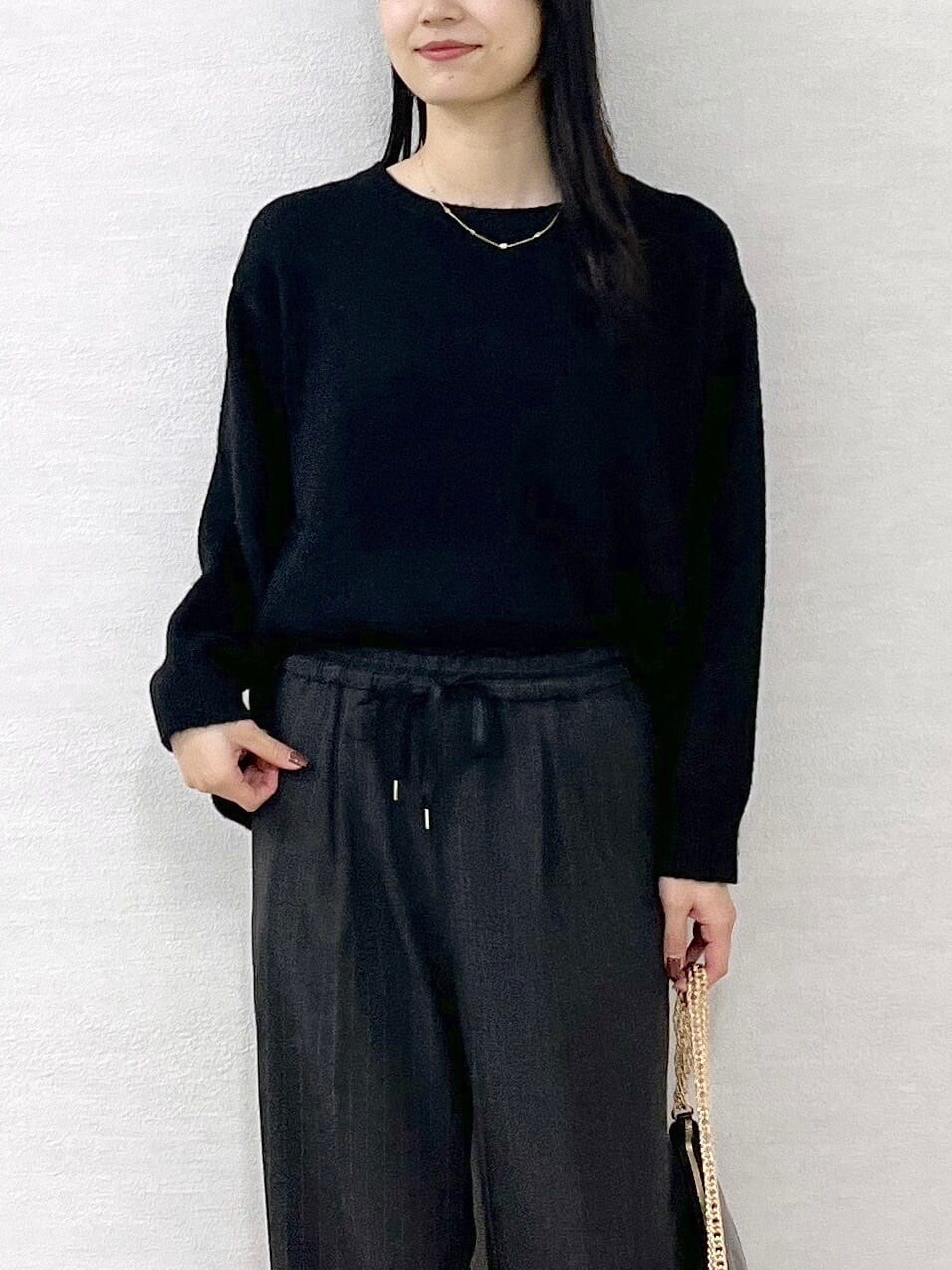 ブラック系のニット/セーター、グレー系のその他パンツ、ブラック系のハンドバッグを着用したレディースの冬コーディネートの6枚目の写真