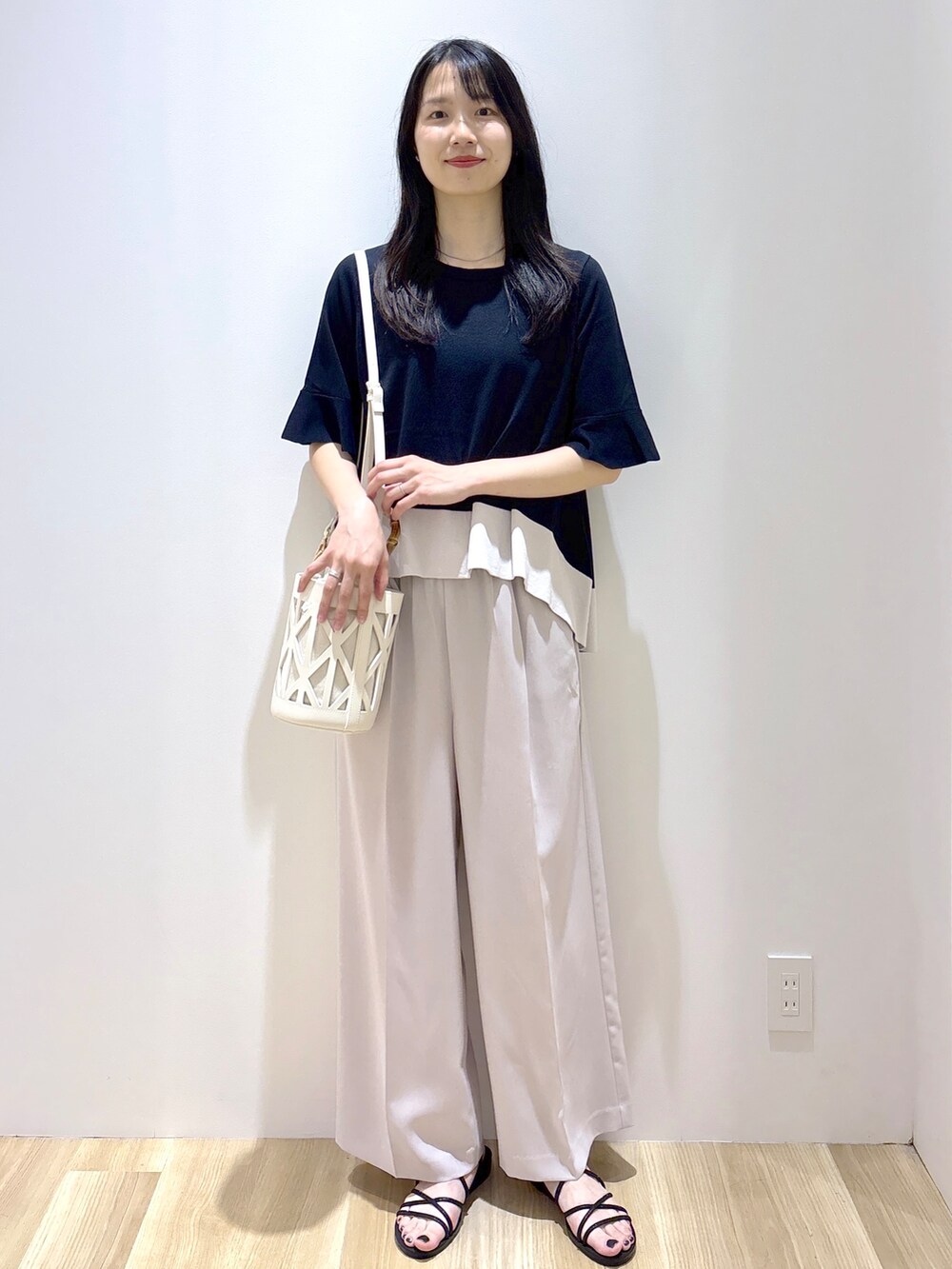 ブラック系のニット/セーター、ベージュ系のその他パンツ、ホワイト系のハンドバッグを着用したレディースの夏コーディネートの8枚目の写真